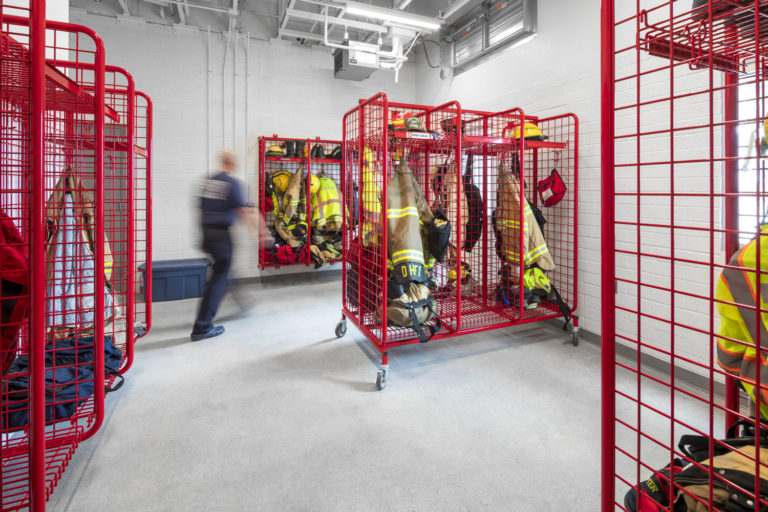 Fire fighter jackets are hung safely on racks in a separate room.