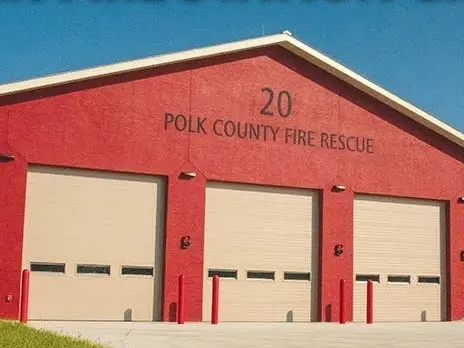 Red building with three light brown firetruck bays and lettering that says 20 Polk County Fire Rescue.